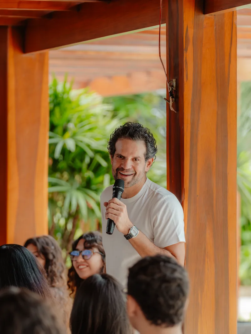 Arnaldo Pinho palestrando com microfone em evento ao ar livre