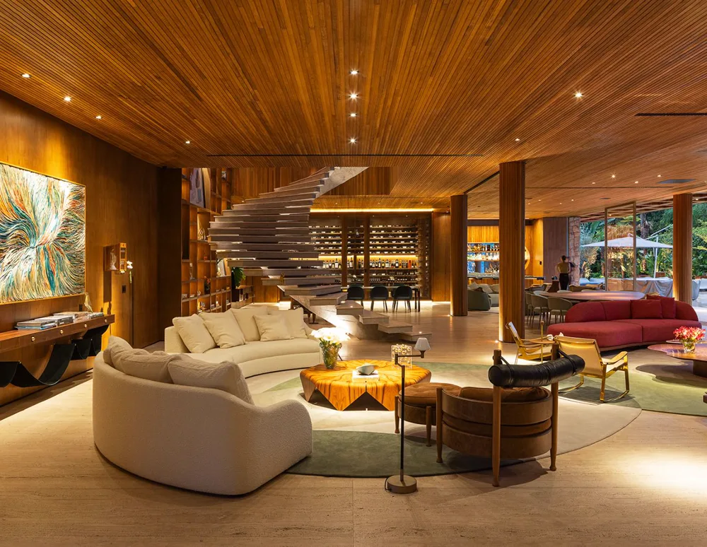 Sala de estar de projeto residencial de alto padrão com escada escultural e forro de madeira